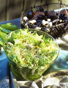 Curly endive with seafood and carambolas in bowl