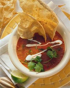 Tomato soup with sour cream; tortilla chips; lime