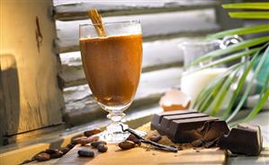 Hot chocolate with cinnamon stick in glass