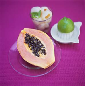 Half a papaya; lychees; lime and lemon squeezer