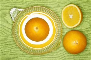 Oranges on lemon squeezer on green wooden background