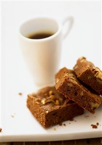 Brownies in front of a cup of coffee