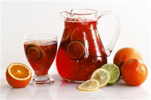 Jug and glass with sangria and citrus fruits