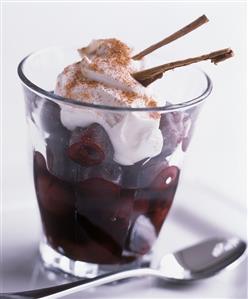 Cinnamon cherries with cream topping in a glass