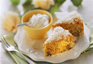 Pieces of coconut cake with dried fruit & bowl of cream (1)