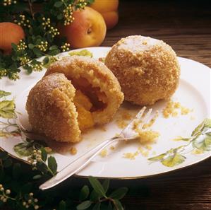 Two apricot dumplings with breadcrumbs, one opened