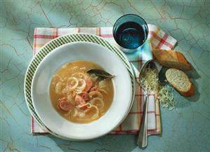 Onion soup with sausage slices and cheese