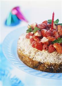 Gateau with raspberries, strawberries, grated coconut & candle