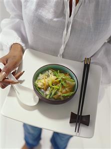 Model holding tray with Asian vegetable soup (1)