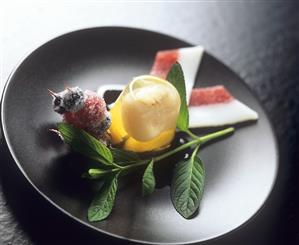 Lychee in jelly garnished with sugared fruit on cocktail sticks