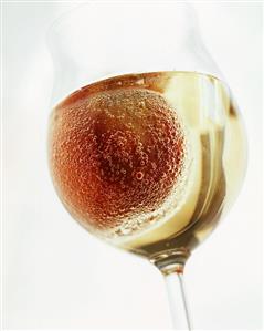 Kullerpfirsich ('rolling' peach in champagne) in glass