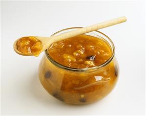 Mango chutney in jar with wooden spoon