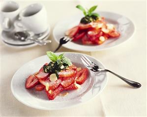 Fresh strawberries with mint pesto, icing sugar, flaked almonds