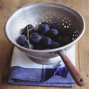 Fresh plums in colander