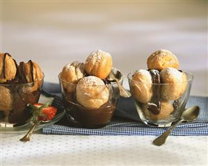 Cream puff with chocolate sauce and icing sugar