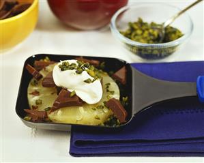 Pineapple raclette with chocolate, cream and pistachios