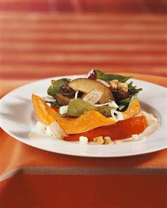 Spinach salad with fruit and fried pumpkin