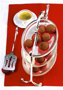 Tiramisu chocolates on tiered stand in front of coffee cup