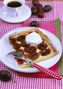 Piece of plum cake with cream, cup of coffee