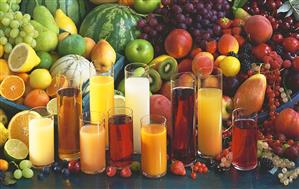 Various types of fruit juice in glasses in front of fresh fruit