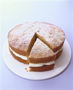 Orange carrot cake with icing sugar, a piece cut