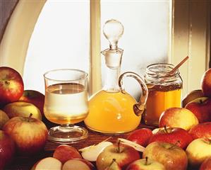 Still life with apple vinegar, honey and fresh apples