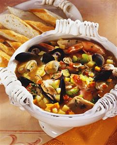 Fish soup with seafood and vegetables, white bread