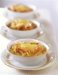 Three bowls of onion soup in a row