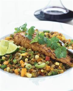 Salmon fillet on lentils with coriander leaves and lime