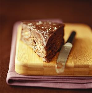 Piece of chocolate cake on chopping board