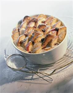 'Log pyre' (bread pudding) with apples, raisins & icing sugar