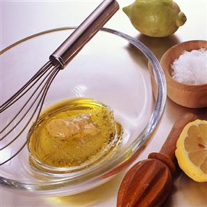 Vinaigrette in glass bowl with mustard, lemon and salt