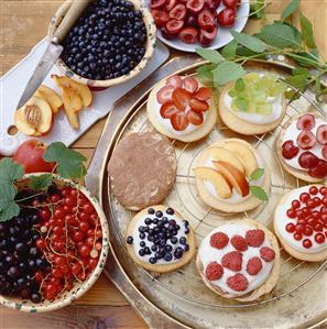 Assorted small sponge cakes with berries and fruit