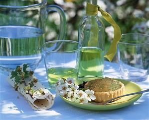 Lime tart and woodruff syrup on table out of doors