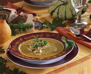 Pumpkin soup with flaked almonds on autumnal table