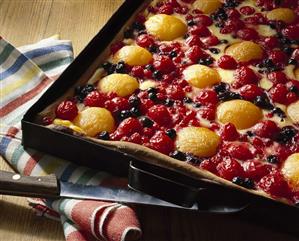 Fruit cake with sour cream custard on baking tray