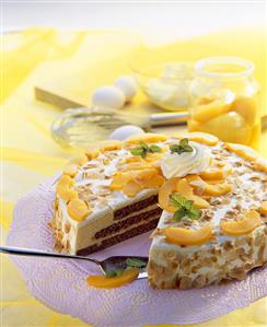 Cream cake with peaches and flaked almonds