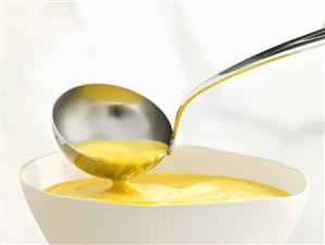 Carrot cream soup in bowl and ladle