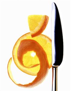 Slice of orange and orange peel with knife