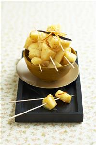 Pineapple chunks on cocktail sticks in a bowl