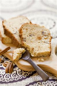 Three slices of banana and pecan loaf on chopping board