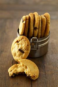 Chocolate chip cookies in and beside a metal container