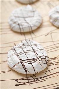 Decorating coconut macaroons with couverture chocolate