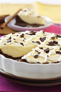 Cream pie with chocolate crust, a piece removed