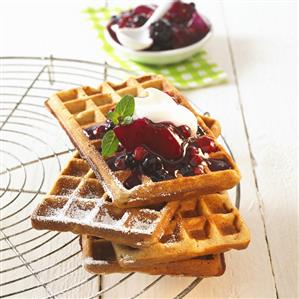 Amaranth waffles with fruit and cream on cake rack