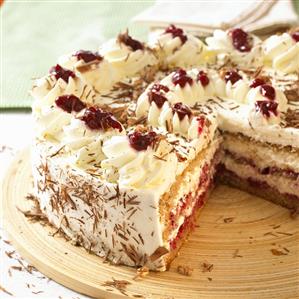 Buckwheat cake with cream and cherries, a piece removed