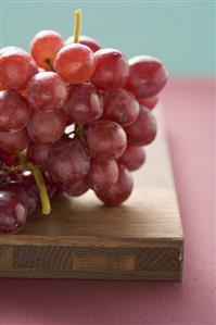 Red grapes on chopping board