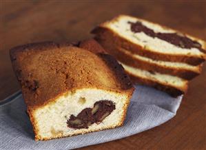 Walnut loaf cake with chocolate, partly sliced