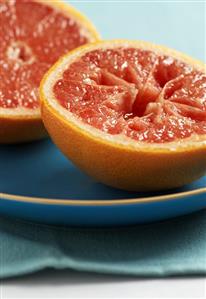 Pink grapefruit, halved, on plate