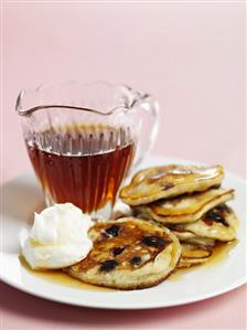 Banana and blueberry pancakes with cream and maple syrup